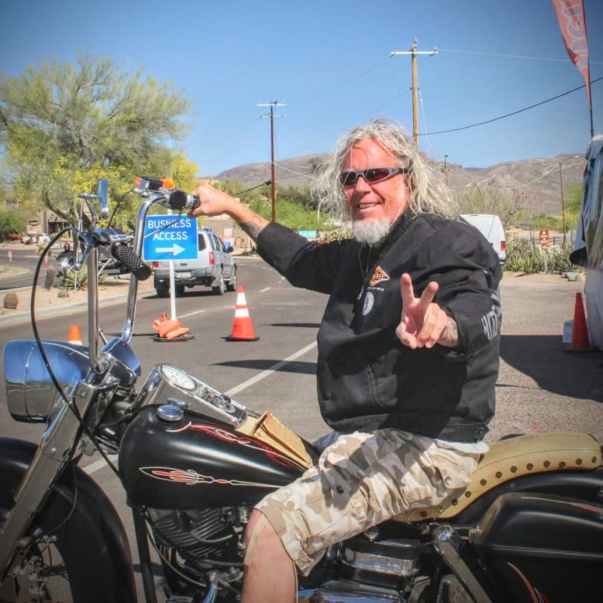 Mark Bradshaw on a motorcycle giving a peace sign