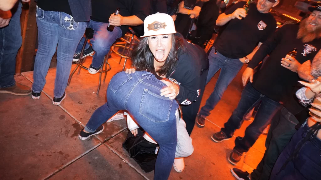 A girl in a Hideaway hat excitedly dancing on another girl's booty